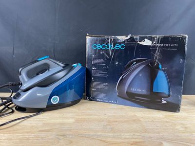 un fer à repasser à vapeur bleu et noir posé sur une table en bois