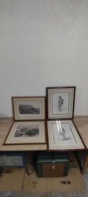 trois photos encadrées posées sur une table, à côté d'une boîte