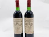deux bouteilles de vin rouge posées l'une à côté de l'autre sur une surface blanche