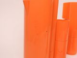 several orange vases are lined up on a white surface