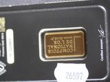 a close up of a gold bar on a black plate