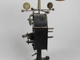 an old fashioned steam engine with a wooden seat on a metal stand