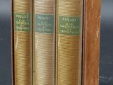 trois livres sont empilés les uns sur les autres sur une surface noire