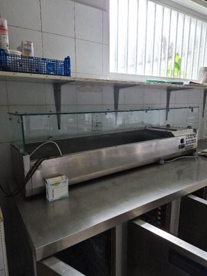 plan de travail en acier inoxydable dans une cuisine professionnelle dotée d'une vitrine en verre