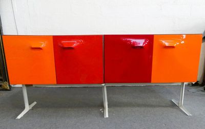 un buffet orange et rouge posé sur un piètement en métal