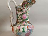 a small vase with a handle on a white table