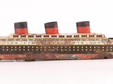 une maquette en bois d'un bateau posée sur une surface blanche