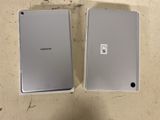 two samsung tablet computers sitting side by side on a table
