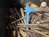 a pile of tools in a metal container with a blue handle