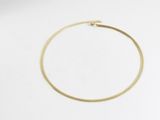 gros plan d'un bracelet en or sur une surface blanche