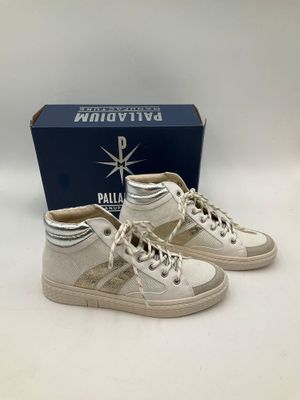 une paire de baskets blanches posée sur une boîte