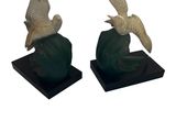 deux statues d'oiseaux posées sur un socle noir