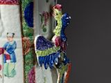 a vase with a bird on it sitting on a table