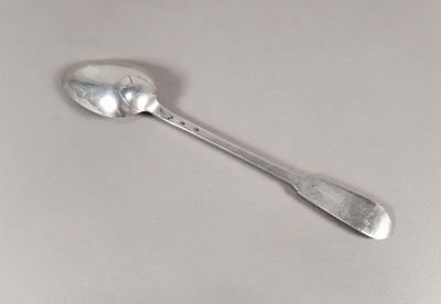 une cuillère en argent avec un manche de cuillère sur une surface blanche