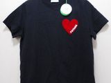 black t - shirt with a red heart on it hanging on a hanger