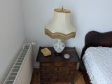 un petit lit dans une petite chambre, avec une lampe sur la table de chevet