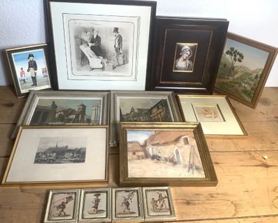 de nombreux tableaux encadrés posés sur une table en bois sur laquelle sont disposées des photos