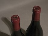 two bottles of wine sitting next to each other on a table