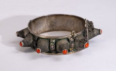 silver bracelet with coral and silver beads on a white surface