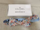 bow tie in a box on a couch with a box in the background