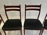 four chairs with black leather upholstered seats in a row
