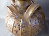 a brown vase with a handle on it on a table