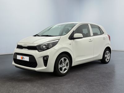 La voiture blanche est garée dans une pièce au sol noir.