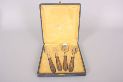 three forks and spoons in a case on a table
