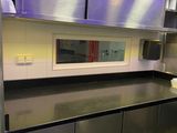 une cuisine avec des placards en inox et des plans de travail noirs