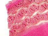 close up of a pink knitted scarf with a white background