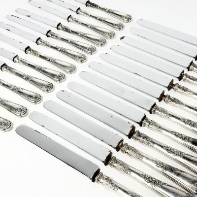 un ensemble de huit couteaux en métal argenté aux manches ouvragés