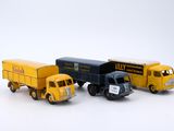 three toy trucks sitting next to each other on a white surface