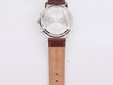 wrist watch with brown leather strap and white dial on a white surface