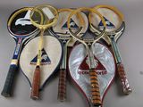 Plusieurs raquettes de tennis sont alignées sur une table