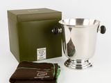 un seau à glace en argent, avec à côté un chiffon marron et une boîte verte