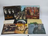 the beatles albums are sitting on a table with a white background