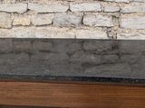 a small table with a black granite top on a stone floor