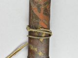a wooden stick with a design on it on a white surface