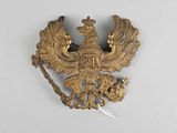 une image représentant un aigle en or auquel est attachée une chaîne dans le dos