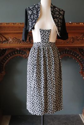 robe noire et blanche sur un mannequin mannequin debout devant une cheminée