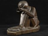 une photo d'une statue en bronze représentant un homme assis sur un banc