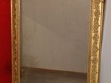 a mirror sitting on the floor next to a red wall