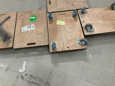quatre morceaux de bois munis de roulettes, posés par terre