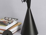 une lampe noire posée à côté d'une pile de livres