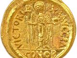 a gold coin with an image of a man holding a sword