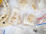 many different types of jewelry in plastic containers