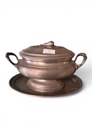 an antique silver plate with a bowl and saucer on it