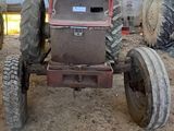 un tracteur qui est à l'abandon dans la boue, dans une grange