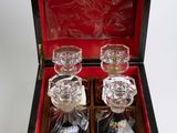 four glasses in a wooden box on a white surface