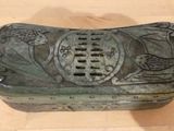 a green box with a design on it on a wooden floor